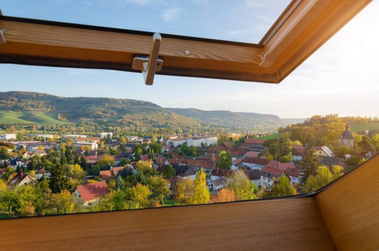 Aussicht aus einem Dachfenster über ein ländliches Wohngebiet.